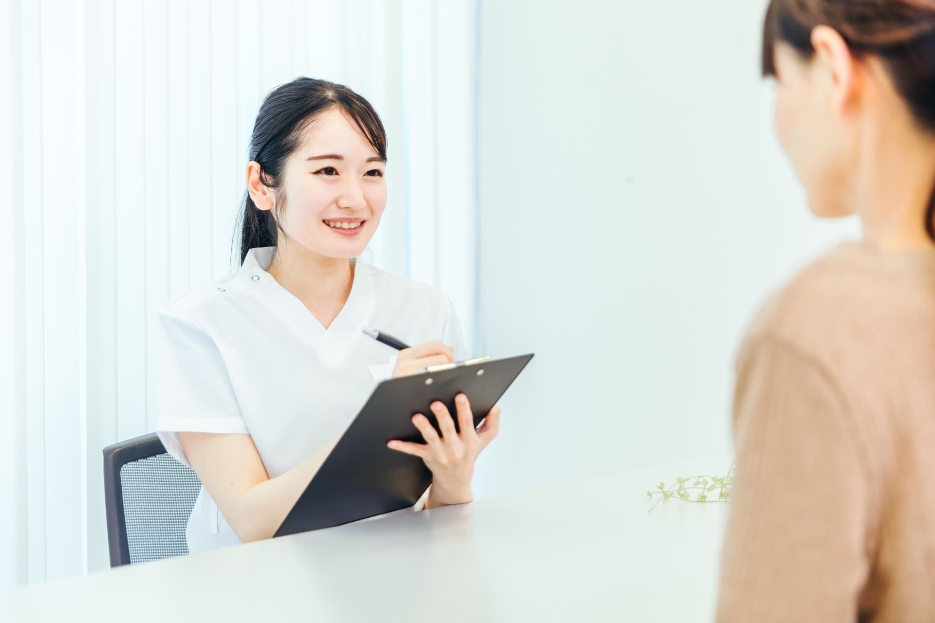 笑顔の看護師が患者の相談を受ける